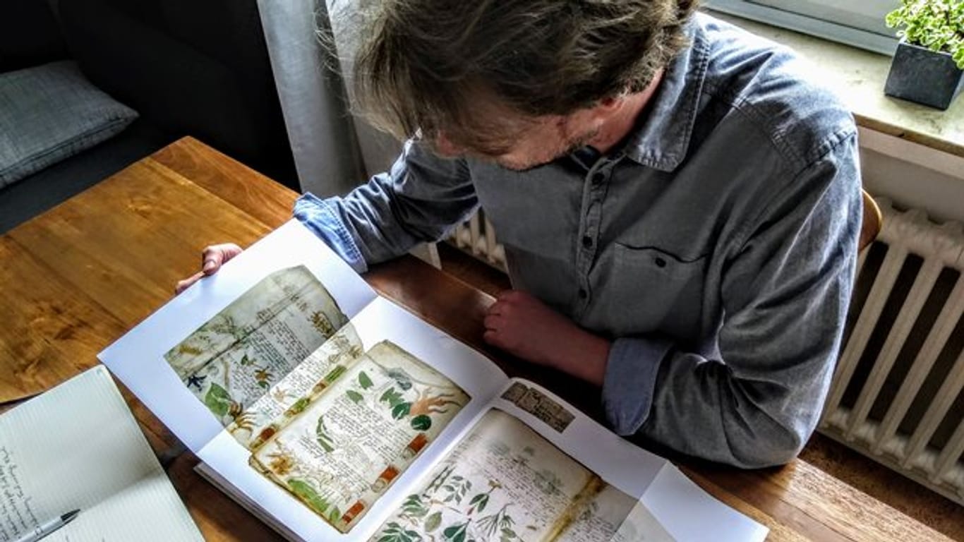 Der Computerlinguistiker Jürgen Hermes mit einem Faksimile des berühmten Voynich-Manuskripts.