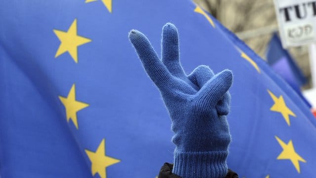 Ein Teilnehmer eines Marsches für Europa zeigt das Victory-Zeichen.