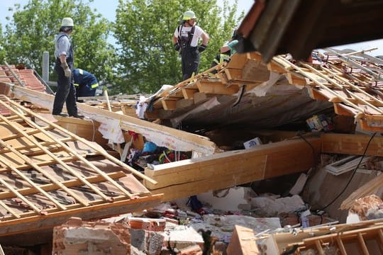 Einsatzkräfte in den Trümmern des zerstörten Hauses im bayerischen Rettenbach.