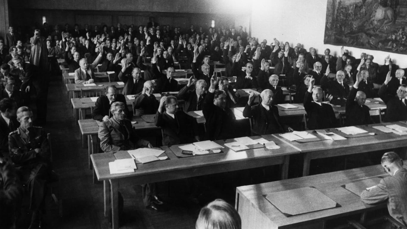 Annahme des Grundgesetzes 1949: Das Plenum des Parlamentarischen Rates nimmt in 3. Lesung am 8. Mai 1949 den revidierten Grundgesetzentwurf mit 53 gegen 12 Stimmen an.