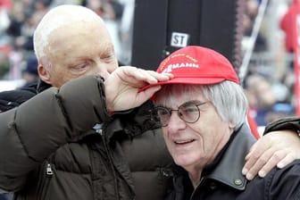 Niki Lauda (l) setzt 2006 dem damalige Formel-1-Chef Bernie Ecclestone seine rote Kappe auf.