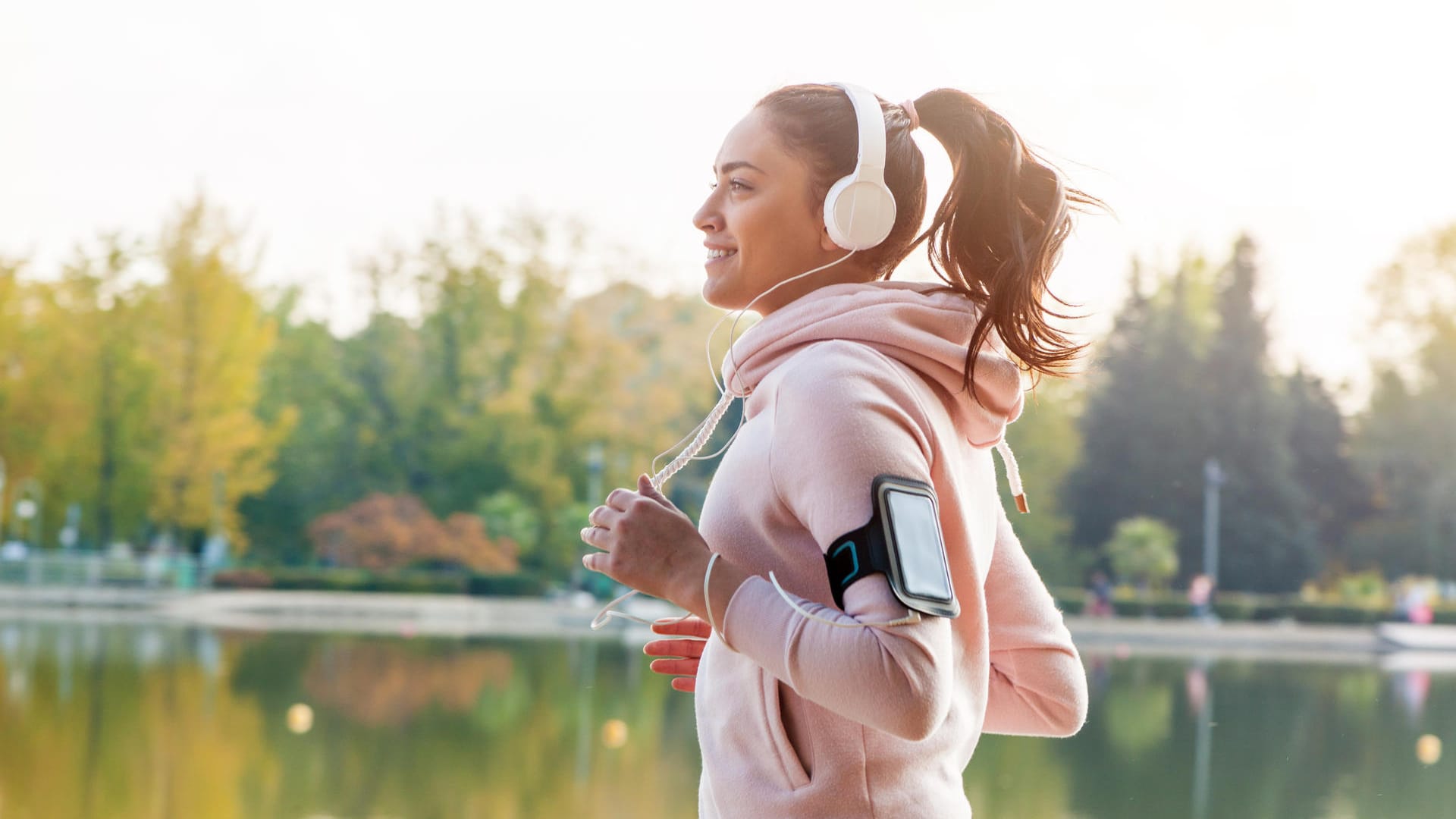 Eine Frau joggt und hört dabei Musik: Die Leistung kann gesteigert werden, wenn man seine Lieblingssongs beim Training hört.