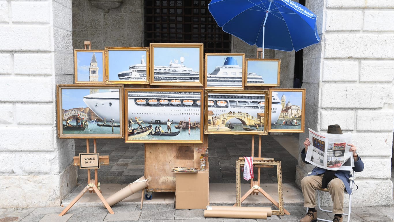 Ein Straßenmaler bietet in der Nähe des Markusplatzes Kunstwerke zum Verkauf an: Vebirgt sich Banksy hinter der Zeitung?