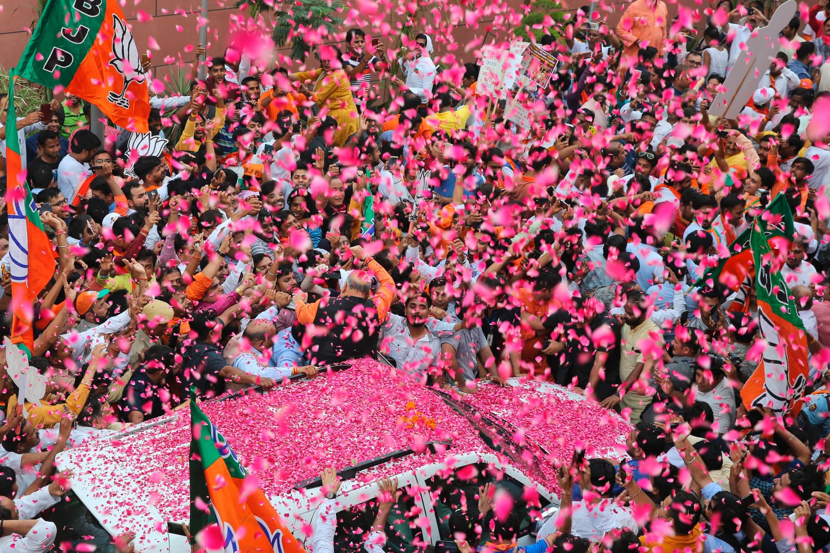 Amit Shah, Vorsitzender der Bharatiya Janata Partei (BJP), wird mit Blütenblätter bei seiner Ankunft am Parteibüro begrüßt. Trotz laufender Stimmzählung hat die BJP bereits ihren Sieg erklärt.