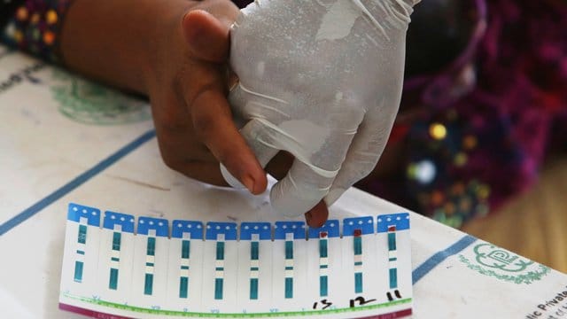 Ein pakistanischer Arzt nimmt in einem Krankenhaus in einem Dorf in der Nähe von Ratodero, einer Kleinstadt in der südlichen Provinz Sindh in Pakistan, an dem Finger eines Dorfbewohners Blut ab.