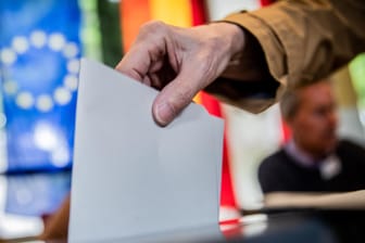 Ein Mann wirft seinen Stimmzettel in Berlin in die Wahlurne: Parallel zur Europawahl wird in Bremen auch eine neue Bürgerschaft gewählt.