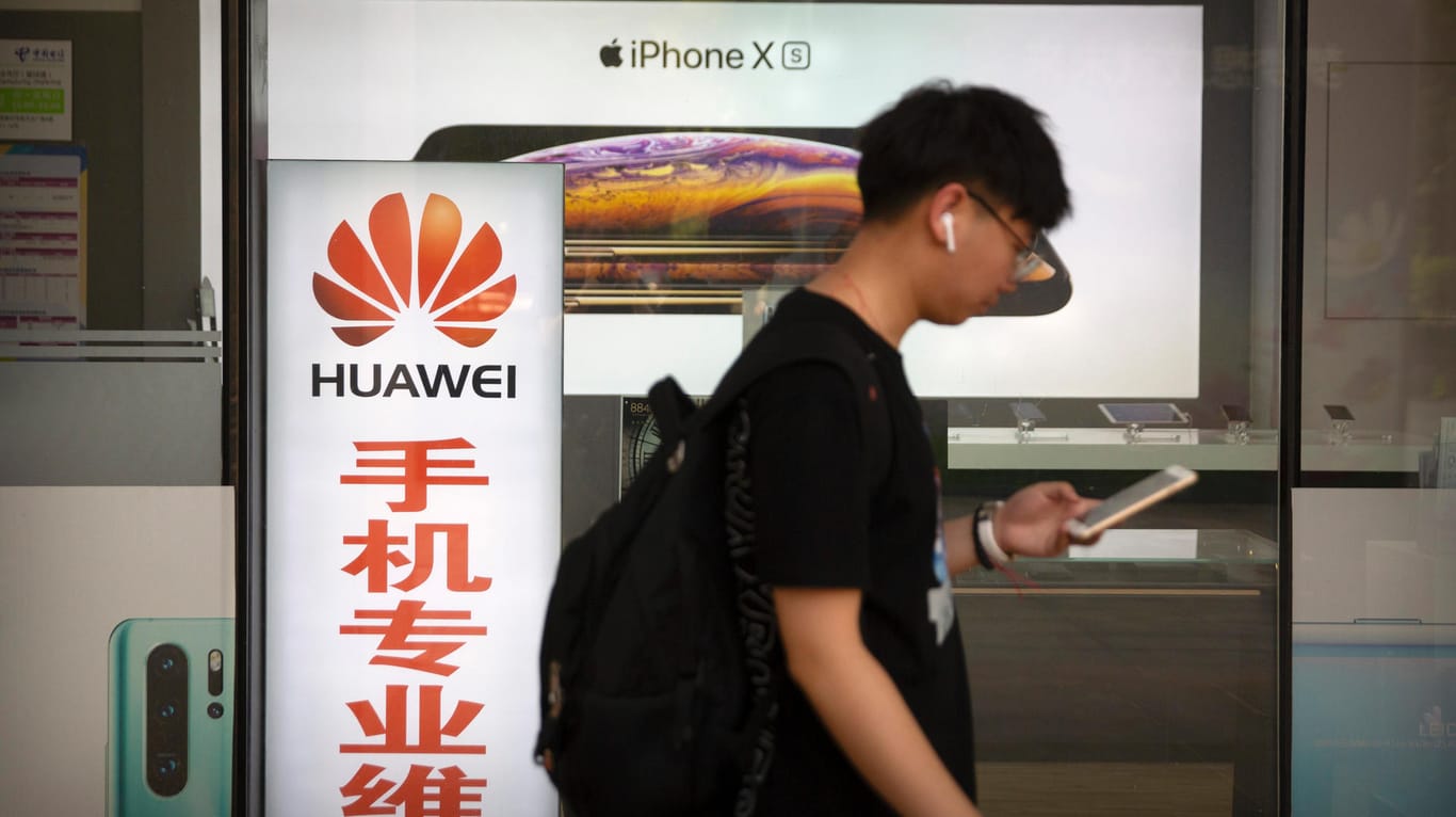 Ein junger Mann geht an einem Elektronikgeschäft mit Huawei-Werbung vorbei: Die USA bezichtigen Huawei der Spionage. Doch es gibt keine Belege dafür.