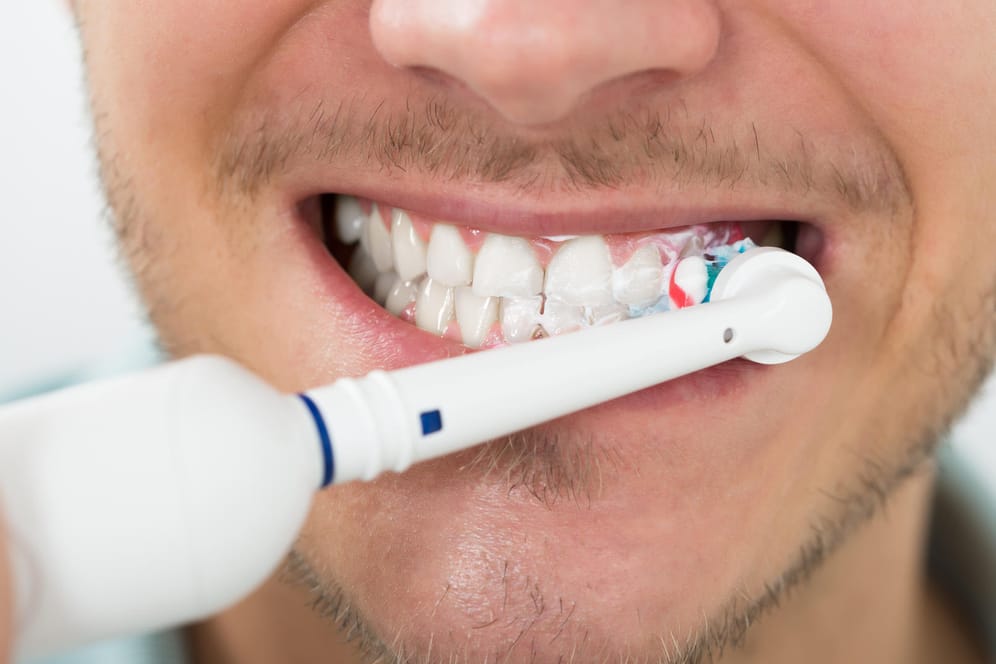 Mann putzt seine Zähne: Dabei geht man am besten immer nach dem gleichen System vor.