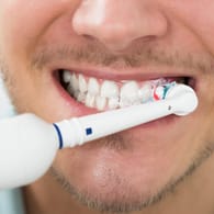 Mann putzt seine Zähne: Dabei geht man am besten immer nach dem gleichen System vor.