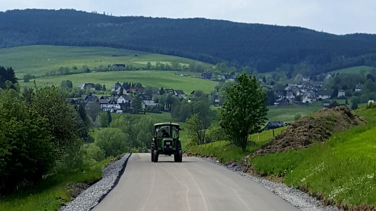 Nordrhein-Westfalen: Spuren von Treckerreifen sind auf einer frisch geteerten Straße zu sehen.