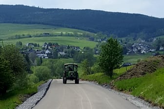 Nordrhein-Westfalen: Spuren von Treckerreifen sind auf einer frisch geteerten Straße zu sehen.