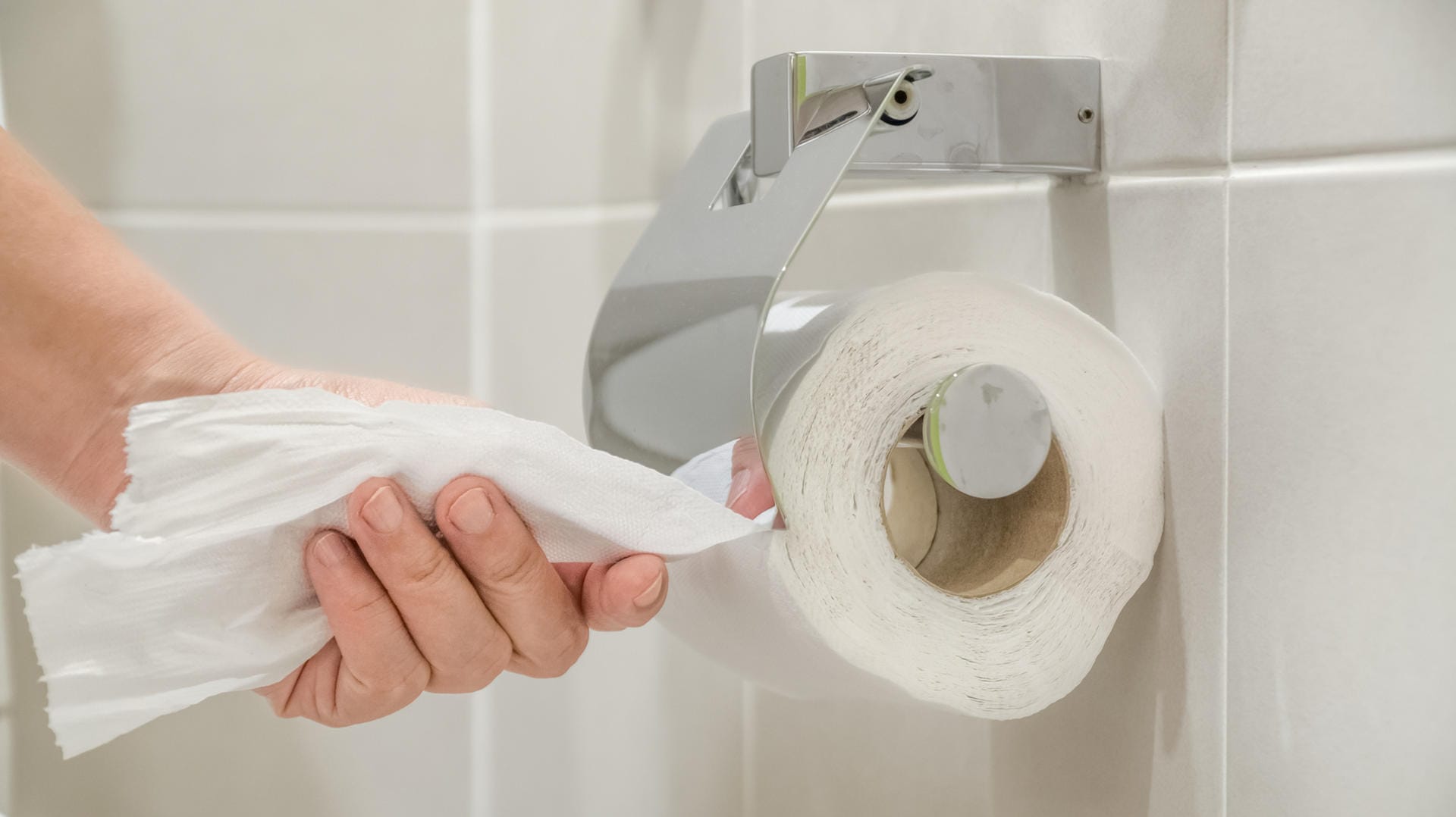 Woman using toilet paper.