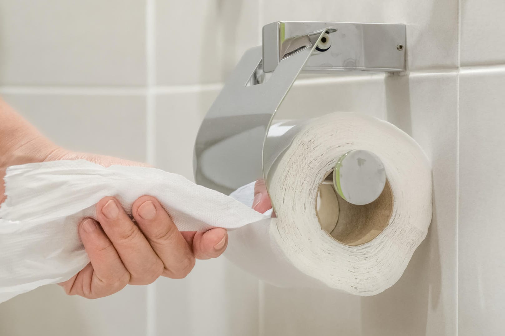 Woman using toilet paper.