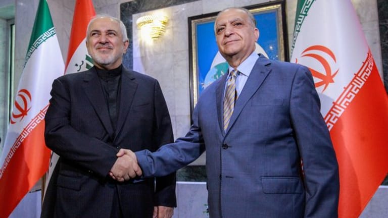 Iraks Außenminister Mohammed Ali Al-Hakim (r) begrüßt seinen iranischen Amtskollegen Mohammed Dschawad Sarif in Bagdad.