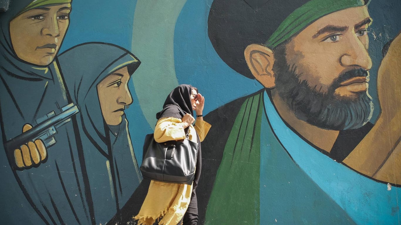 Eine Frau spaziert in Teheran an einem Wandgemälde vorbei: Der Iran verschärft den Ton gegenüber den Vereinigten Arabischen Emiraten.
