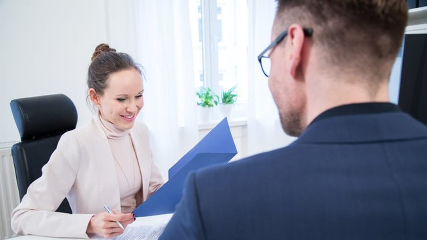 Gespräch zwischen Mann und Frau: Mit einem positiven Referenzschreiben können Bewerber bei einem potenziellen Arbeitgeber punkten. (Symbolbild)