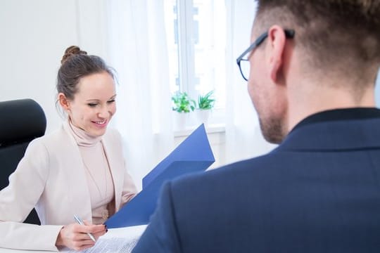 Gespräch zwischen Mann und Frau: Mit einem positiven Referenzschreiben können Bewerber bei einem potenziellen Arbeitgeber punkten. (Symbolbild)