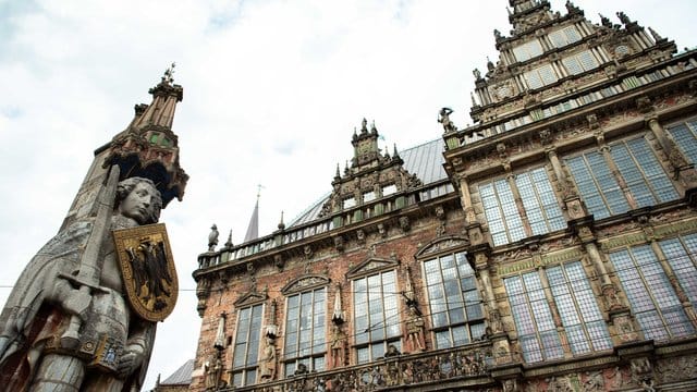 Ein Blick auf den Roland (l) neben dem Alten Rathaus in Bremen.