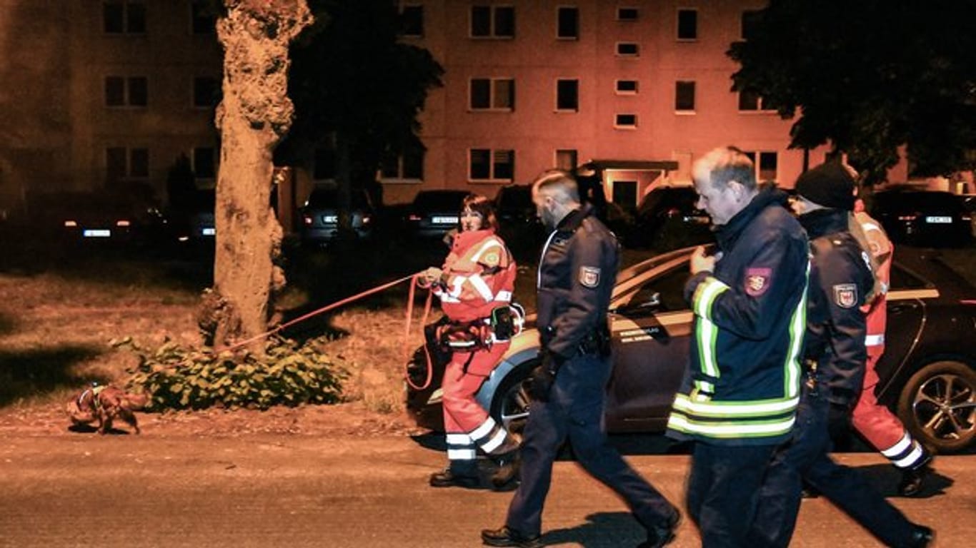 Polizisten und ein Feuerwehrmann begleiteten Mitarbeiterinnen der Rettungshundestaffel bei der Suche nach der vermissten 6-Jährigen in Potsdam.