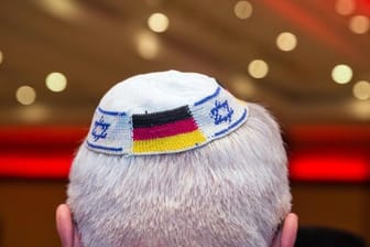 Ein Mann trägt eine Kippa mit eingearbeiteten israelischen und deutschen Fahnen.