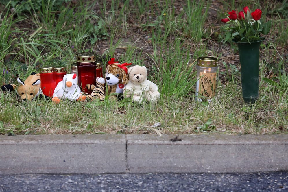 Blumen, Kerzen und Plüschtiere stehen am Straßenrad: An dieser Stelle fand eine Frau am Samstag einen nackten toten Säugling.