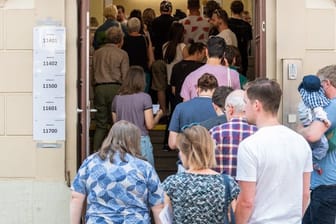 Wähler stehen zur Stimmabgabe bei den Kommunalwahlen in Sachsen vor einem Wahllokal an.