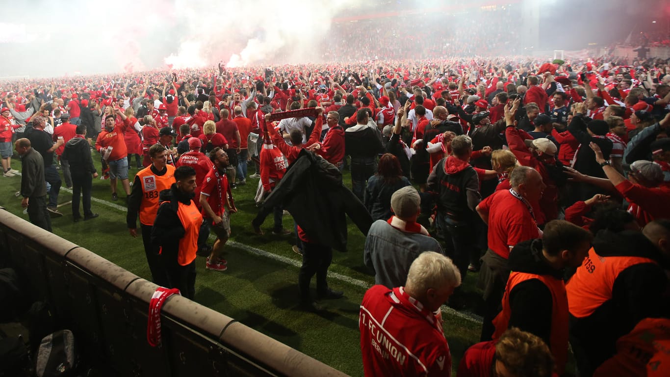 Emotionen pur nach dem Abpfiff: Die Fans von Union Berlin feiern auf dem Spielfeld den Aufstieg.