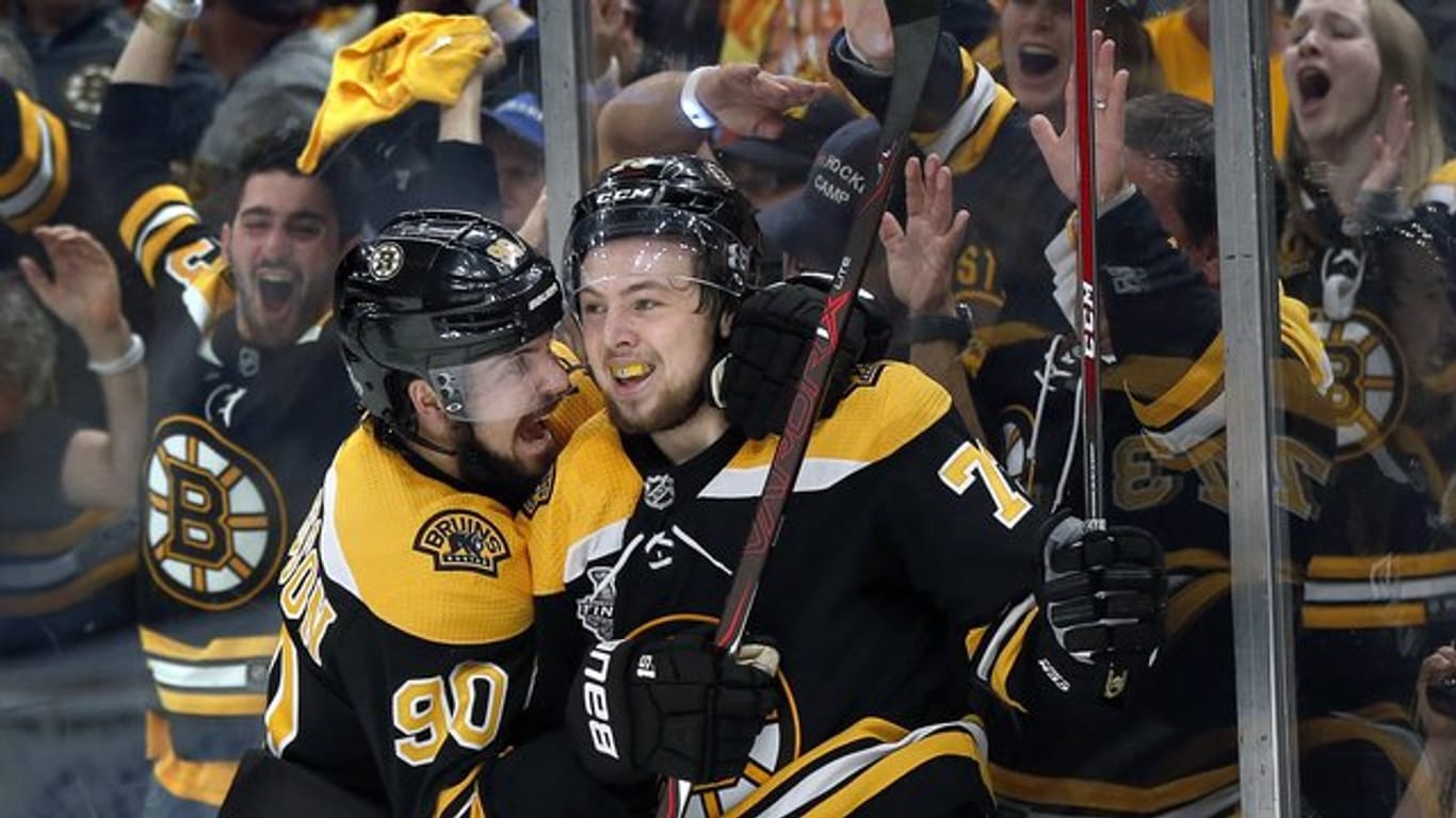 Marcus Johansson (l) und Charlie McAvoy von den Boston Bruins feiern den Sieg gegen die St.