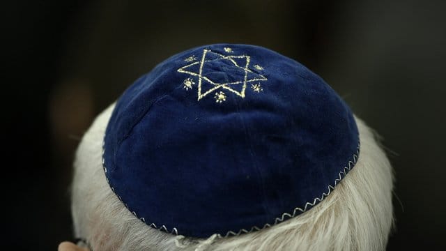 Ein Mann mit Kippa in einer Synagoge.