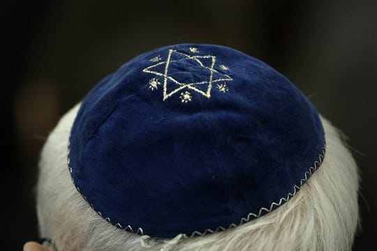 Ein Mann mit Kippa in einer Synagoge.