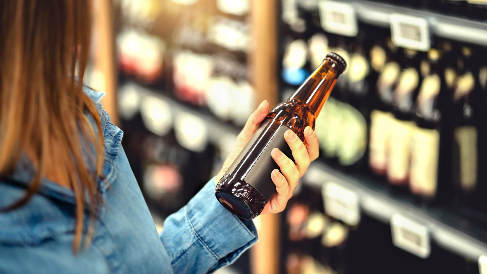 Kundin kauft Bier im Supermarkt: "Öko-Test" hat verschiedene Pilsmarken einer Untersuchung unterzogen.