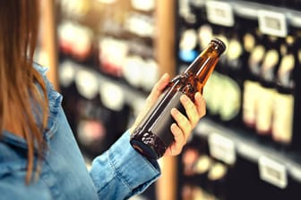 Kundin kauft Bier im Supermarkt: "Öko-Test" hat verschiedene Pilsmarken einer Untersuchung unterzogen.