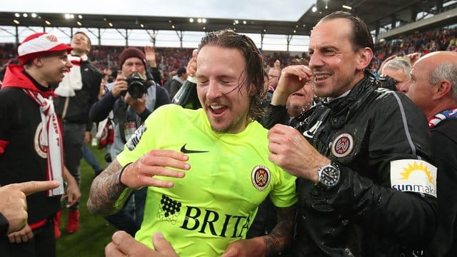 Wiesbadens Moritz Kuhn (l) jubelt mit seinem Trainer Rüdiger Rehm über den Aufstieg in die 2.