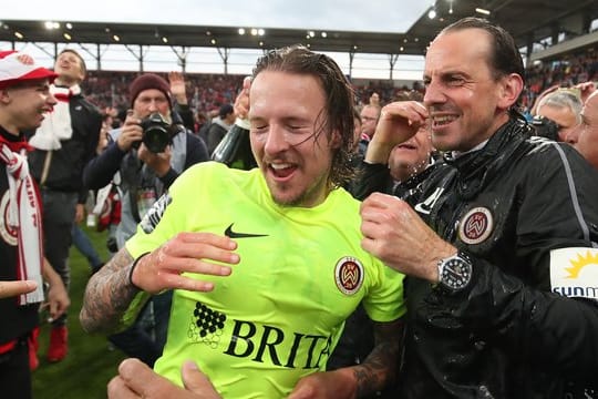 Wiesbadens Moritz Kuhn (l) jubelt mit seinem Trainer Rüdiger Rehm über den Aufstieg in die 2.