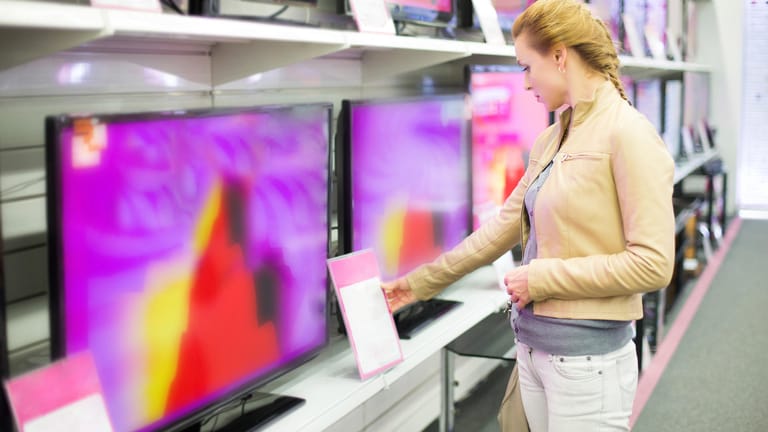 Eine Frau sieht sich neue Fernseher in einem Elektronikmarkt an: UHD, OLED, HDR und so weiter – die Abkürzungen auf dem TV-Markt können verwirrend sein.