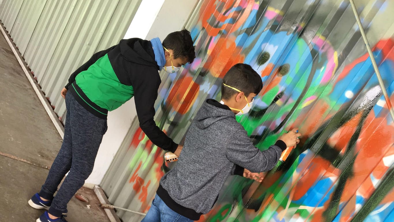 Jugendliche haben in einem Workshop die Tribüne in einer Sportanlage mit Graffiti verschönert.