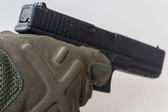 Eine Person hält eine Pistole (Symbolbild): Im tschechischen Regierungsflieger hat sich ein Schuss gelöst.
