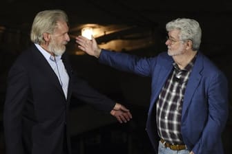 George Lucas (r) begrüßt Harrison Ford bei der Eröffnungsfeier des "Star Wars: Galaxy's Edge"-Themenparks.
