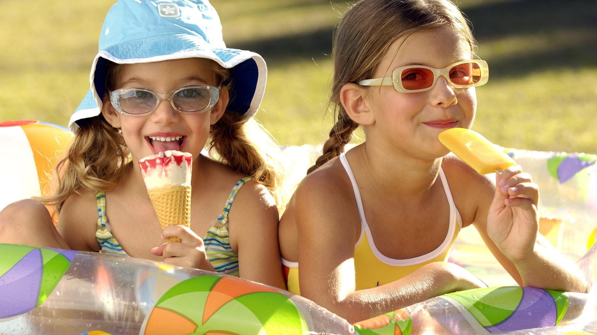 Zwei Mädchen essen Eis: Es wird heiß – da wird wohl auch das ein oder andere Eis drin sein.