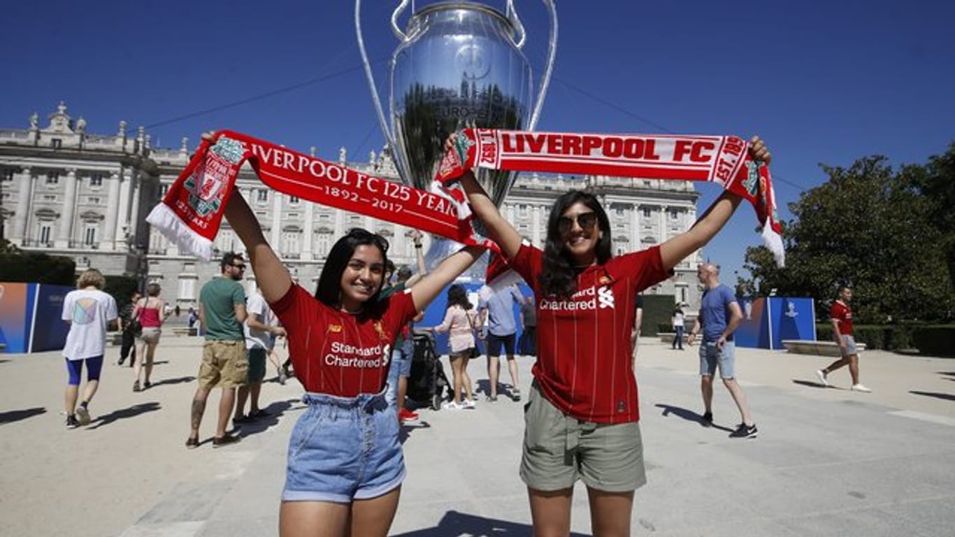 Zwei Liverpool-Anhängerinnen lassen sich vor einer riesigen Replik des Champions-League-Pokals fotografieren.