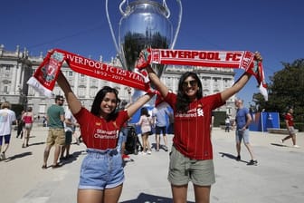Zwei Liverpool-Anhängerinnen lassen sich vor einer riesigen Replik des Champions-League-Pokals fotografieren.