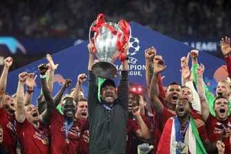 Liverpool-Coach Jürgen Klopp (M) streckt den Champions-League-Pokal in den Nachthimmel von Madrid.