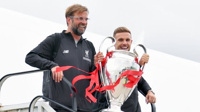 Jürgen Klopp und Jordan Henderson kommen mit der Trophäe am John Lennon Flughafen in Liverpool an. Jürgen Klopp und Jordan Henderson kommen mit der Trophäe am John Lennon Flughafen in Liverpool an.