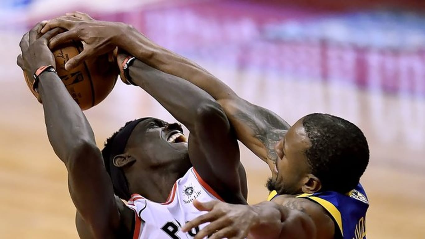 Pascal Siakam (l) von den Toronto Raptors im verteidigt den Ballbesitz gegen Andre Iguodala von den Golden State Warriors.