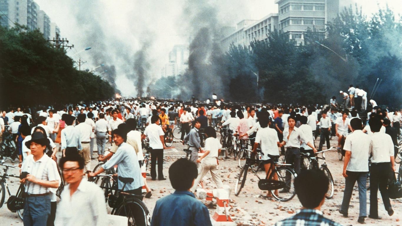 Rauchsäulen, Verwüstung und ratlose Menschen auf der Changan Avenue in Peking. Vor 30 Jahren kam es dort zu einem Massaker.