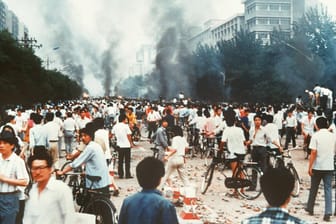 Rauchsäulen, Verwüstung und ratlose Menschen auf der Changan Avenue in Peking. Vor 30 Jahren kam es dort zu einem Massaker.