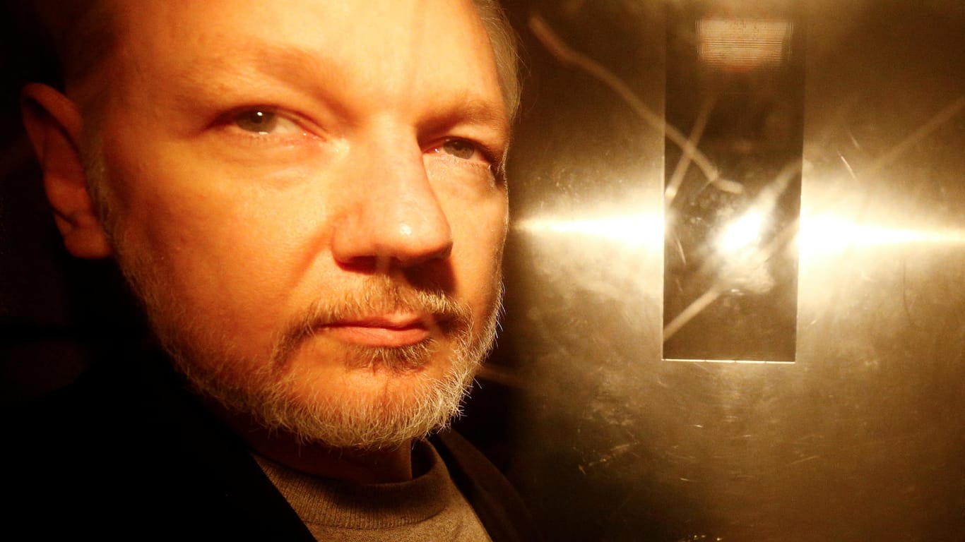 Julian Assange nach einer Gerichtsverhandlung in London in einem Polizeifahrzeug.