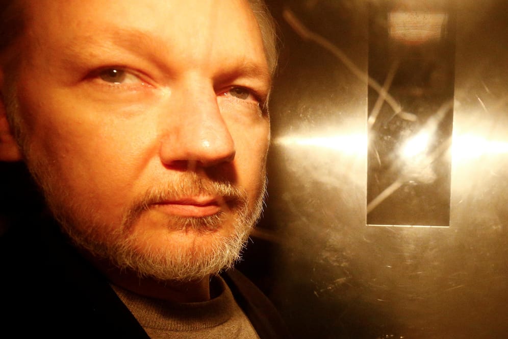 Julian Assange nach einer Gerichtsverhandlung in London in einem Polizeifahrzeug.