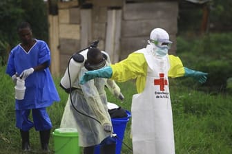 Helfer reinigen sich nach der Arbeit in einem Behandlungszentrum gegen Ebola mit Desinfektionsmittel.