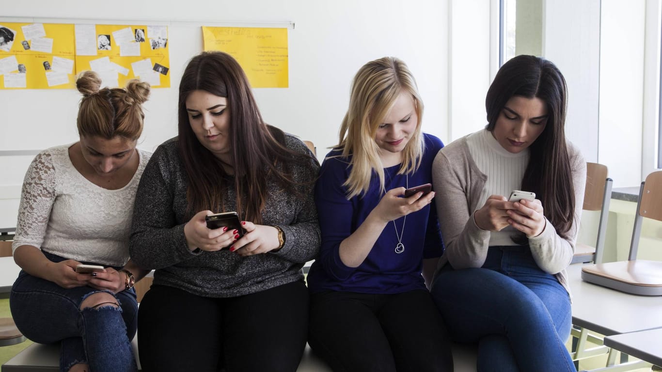 Schülerinnen schauen auf ihre Smartphones: 47 Prozent der Jugendlichen nutzen die Youtube-App zu lernen.